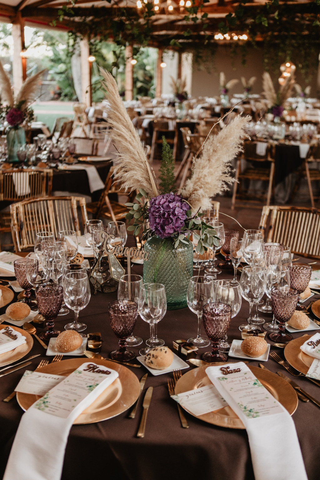 Elegant dekorierter Banketttisch auf Teneriffa mit Blumen, Gläsern und personalisierten Speisekarten.