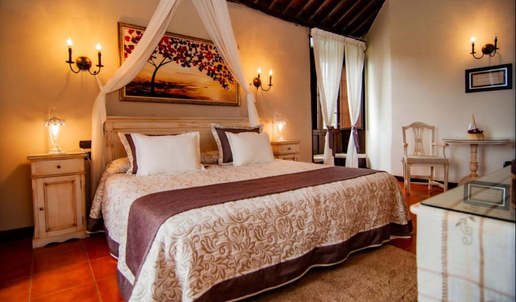 Rustikales Hotelzimmer auf Teneriffa mit Doppelbett und klassischer Einrichtung.