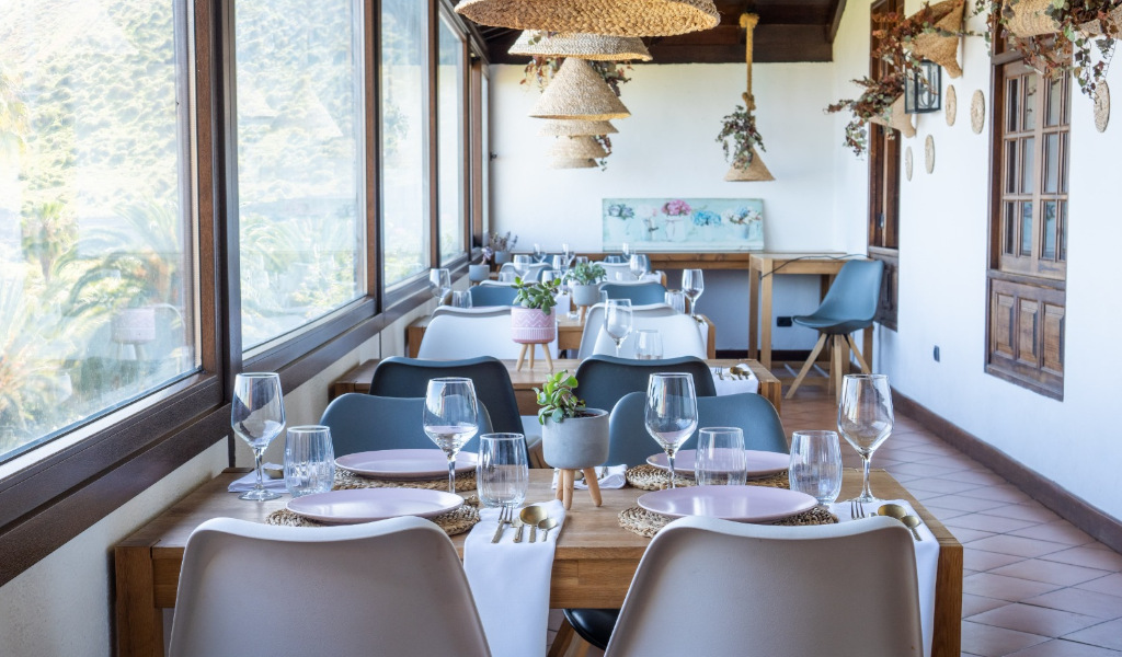 Restaurant auf Teneriffa mit Tischen neben Fenstern und Dekorationen.