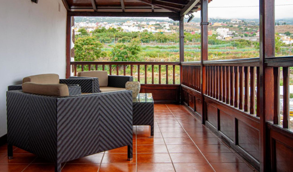 Terrasse mit braunen Sesseln auf Teneriffa, Blick auf die Landschaft und Häuser im Hintergrund.
