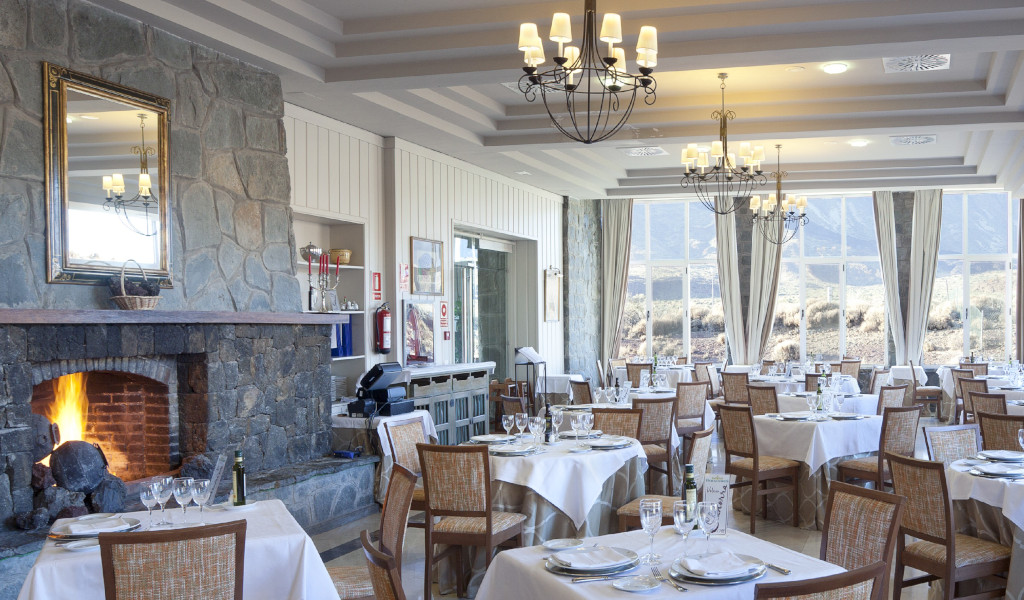 Restaurant auf Teneriffa mit Kamin und elegant arrangierten Tischen.