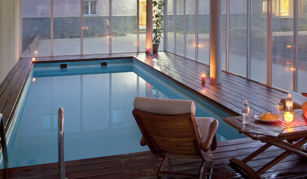 Hallenbad mit Stühlen, Tisch und Kerzen in einem Hotel auf Teneriffa.