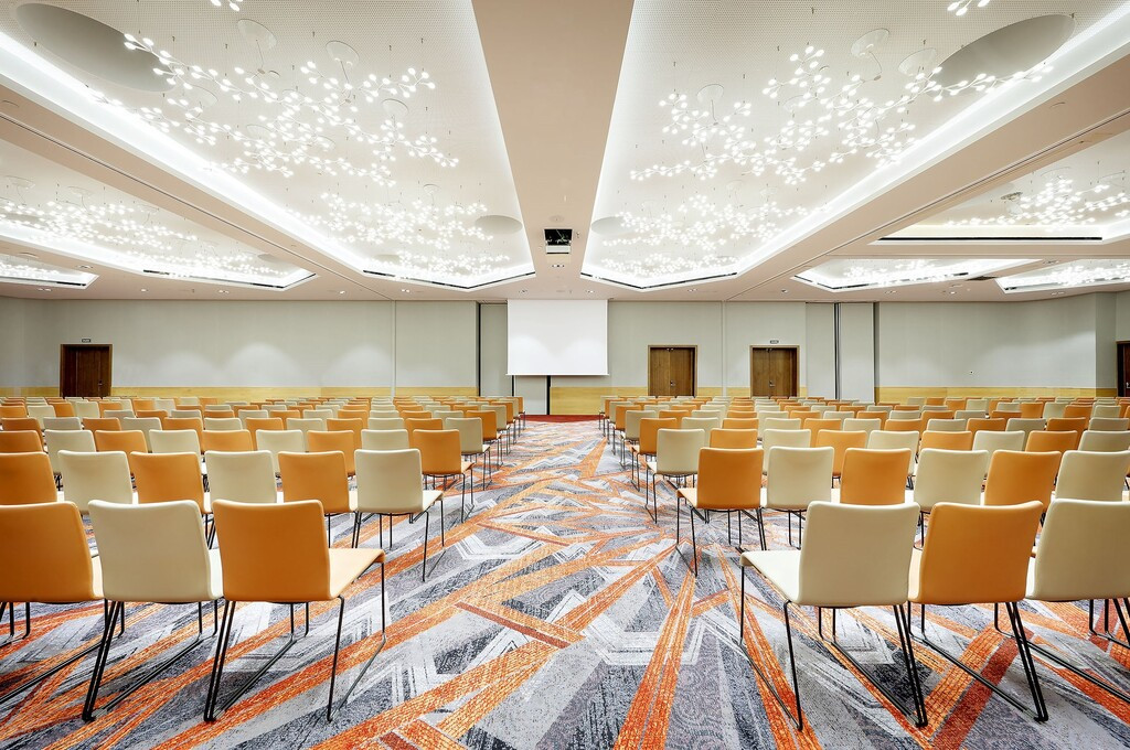 Ein leerer Konferenzraum auf Teneriffa, mit aufgereihten Stühlen und beleuchteter Decke.