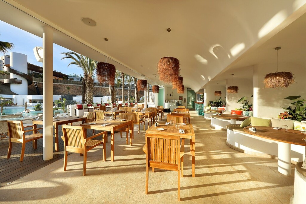 Freiluftrestaurant mit Holzstühlen und Blick auf das Becken auf Teneriffa.