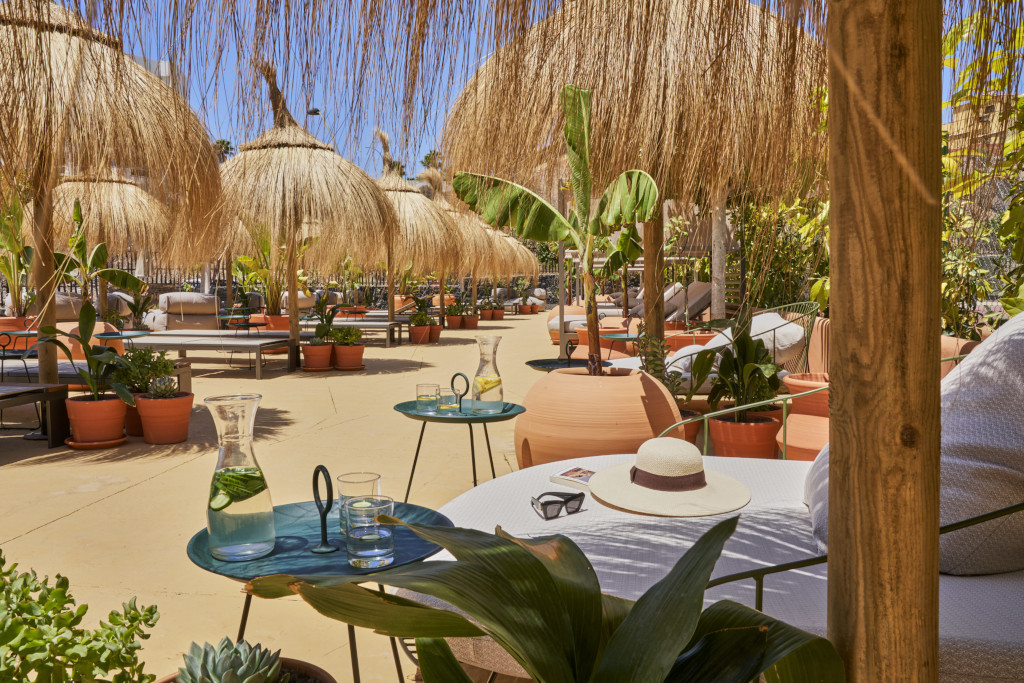 Terrasse mit Strohschirmen und Pflanzen in einem Innenhof auf Teneriffa.