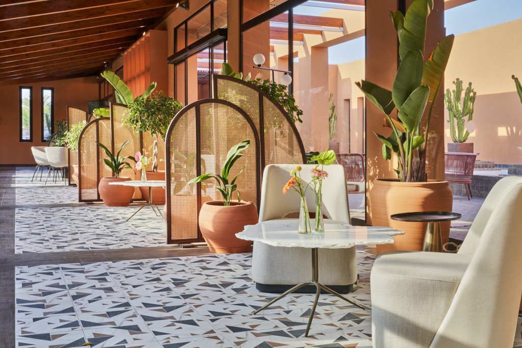 Terrasse mit Stühlen, Tischen und Pflanzen in einem Hotel auf Teneriffa.