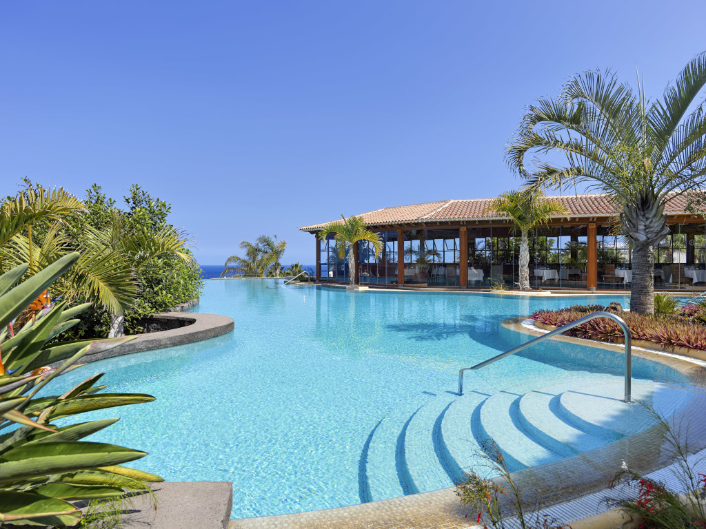 Schwimmbad umgeben von Palmen und Restaurant auf Teneriffa.