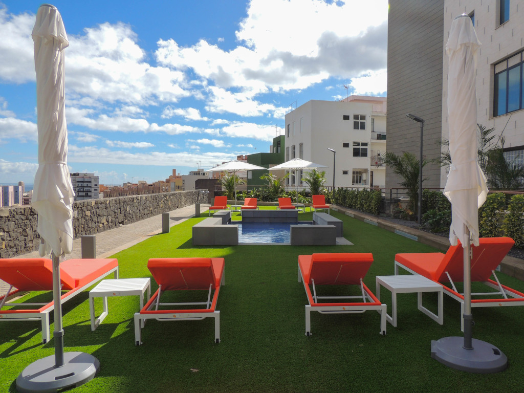 Sonnenliege und Sonnenschirme auf einer Terrasse mit Stadtblick in Santa Cruz de Tenerife.