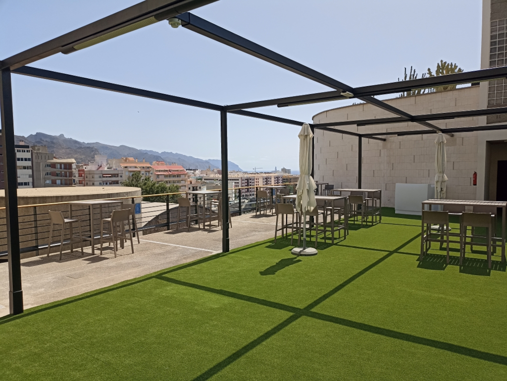Terrasse mit Tischen und Stühlen, Blick auf Santa Cruz de Tenerife im Hintergrund.