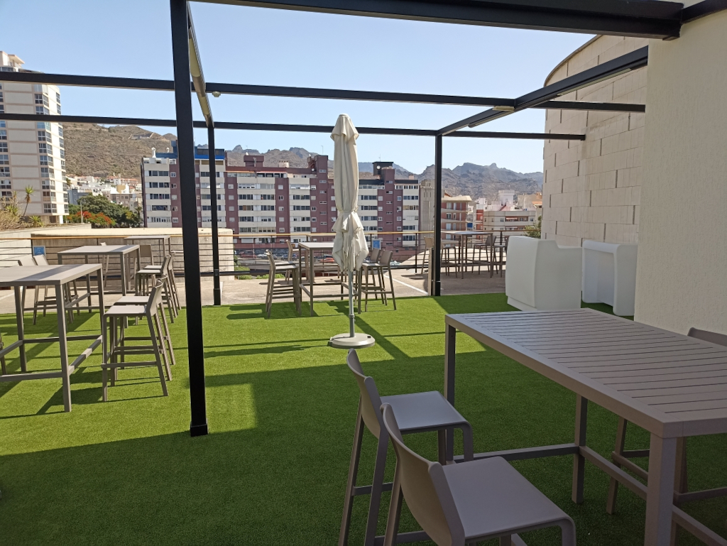 Terrasse mit Tischen und Stühlen mit Blick auf Gebäude in Santa Cruz de Tenerife.