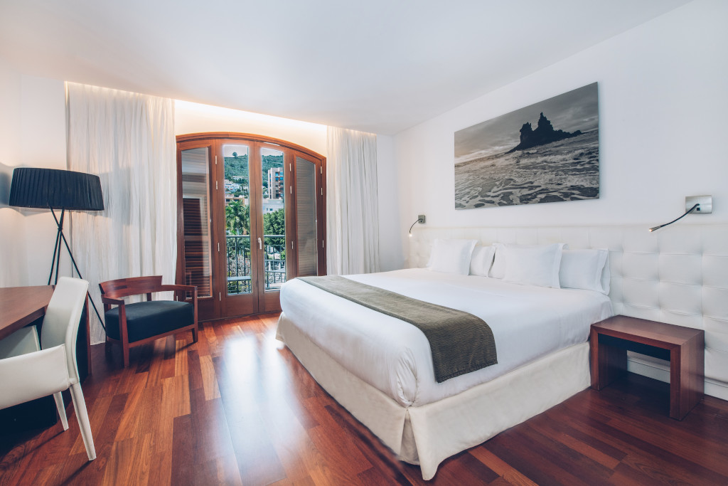 Modernes Zimmer mit Doppelbett, Schreibtisch und Fenster mit Blick auf Teneriffa.