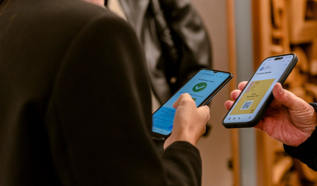 Zwei Personen überprüfen QR-Codes auf Handybildschirmen.
