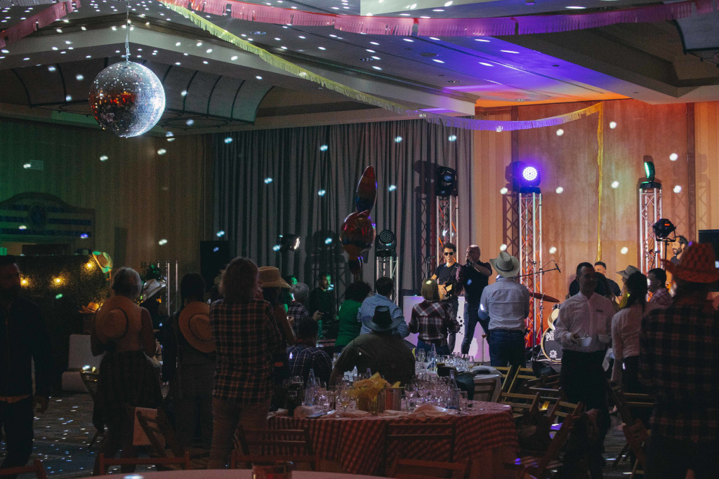 Menschen, die eine Party mit Lichtern und einer Spiegelkugel in einem Wohnzimmer auf Teneriffa genießen.