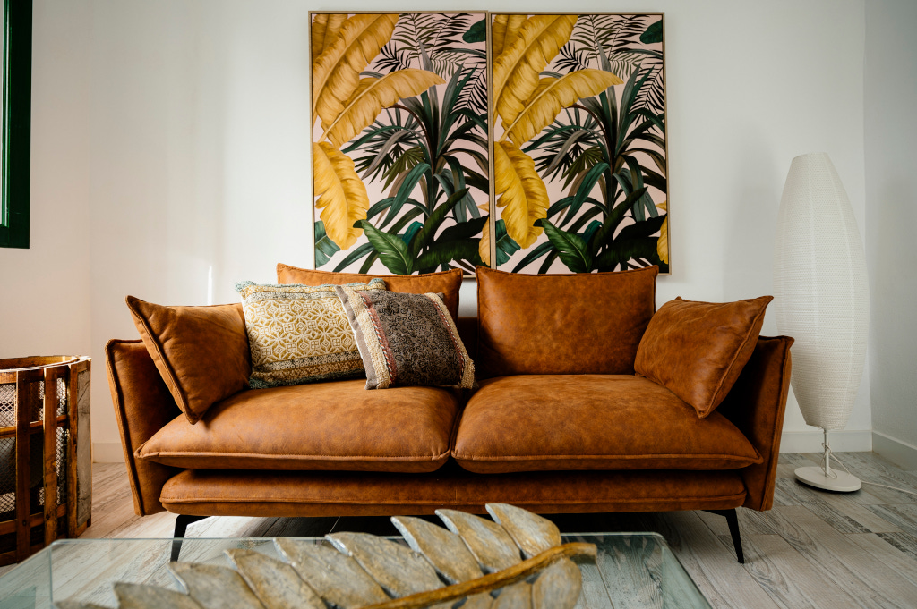 Braunes Ledersofa mit Kissen, Wandkunst mit Pflanzen im Wohnzimmer in Tenerife.