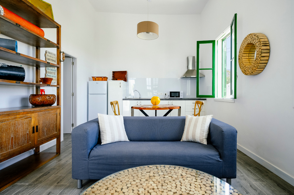 Küche mit Sofa, Esstisch, Fenster mit grünen Rahmen im Haus in Teneriffa.