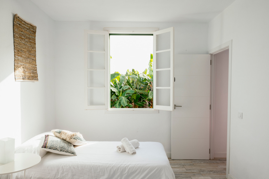 Schlafzimmer mit offenem Fenster und Aussicht auf Garten in Tenerife.