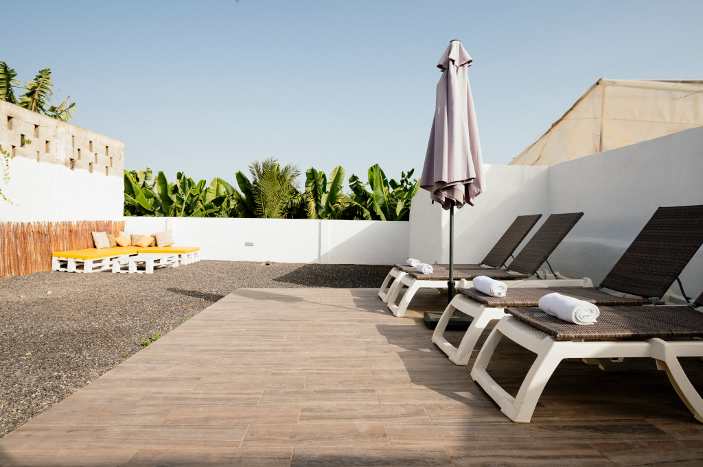Sonnenliegen und Palettenbänke in einem Innenhof in Tenerife.