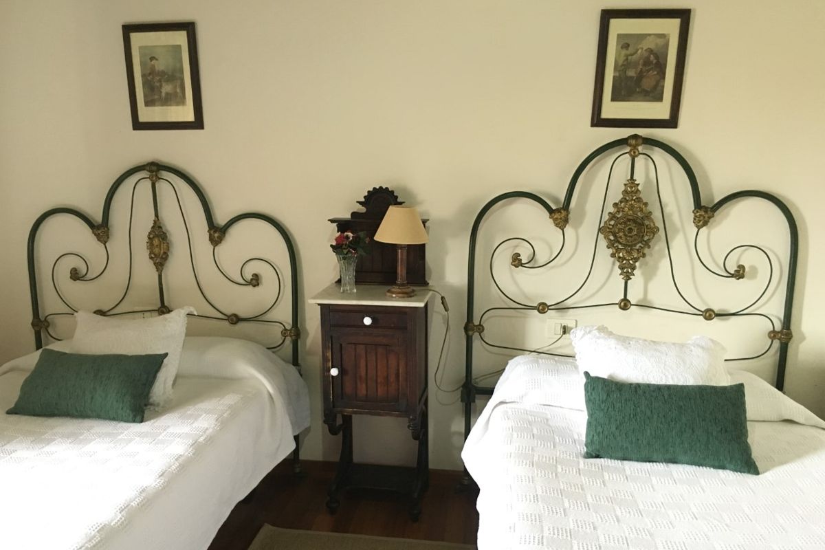 Zwei antike Metallbetten mit Beistelltisch im Zimmer von Tenerife.