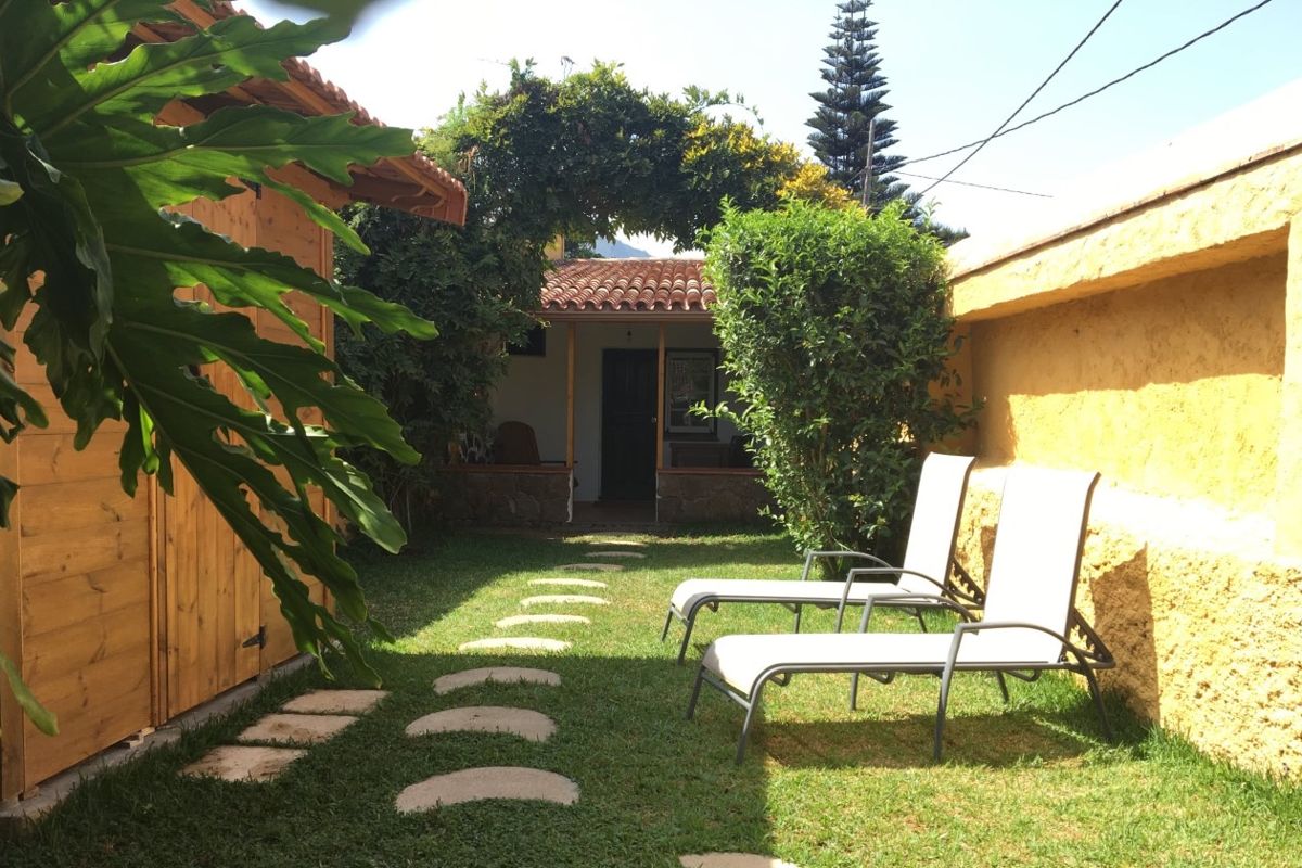 Garten in La Orotava, Teneriffa mit Liegestühlen und Steinweg.