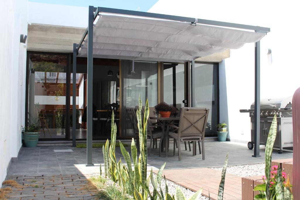 Überdachte Terrasse mit Holzmöbeln und Grill in einem Haus in Teneriffa.