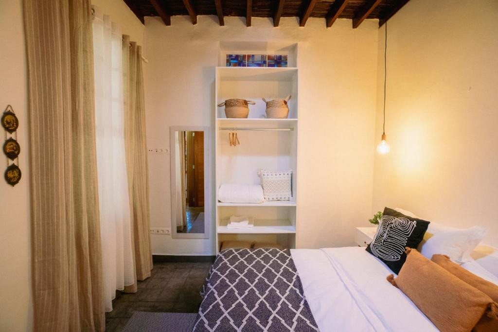 Gemütliches Zimmer auf Teneriffa mit Bett, Handtuchhalter und schlichter Einrichtung.