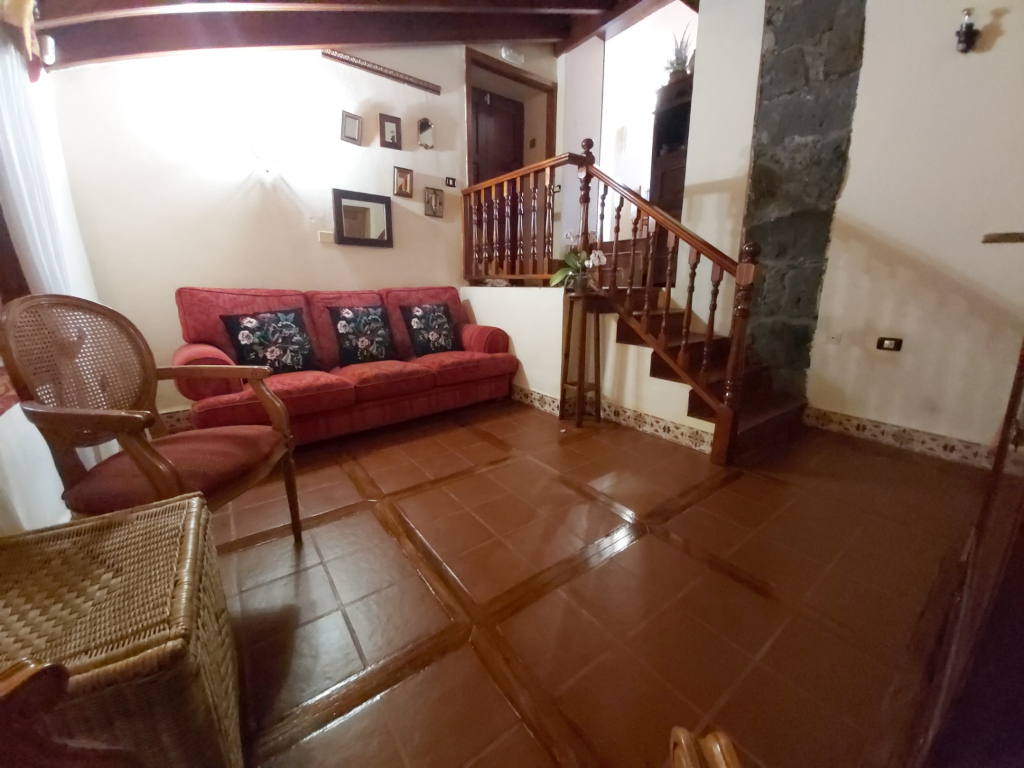 Wohnzimmer mit rotem Sofa und Holztreppe in La Orotava, Teneriffa.