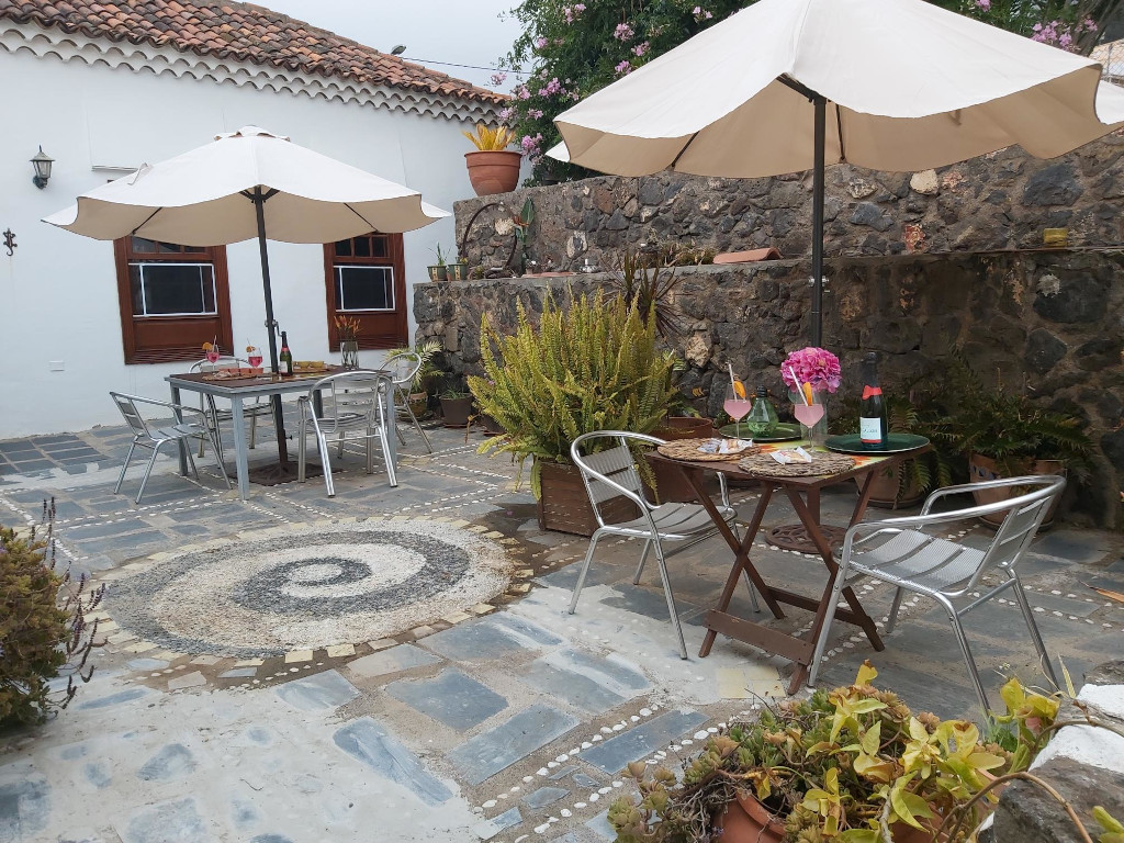 Gartenbereich mit Tischen, Stühlen und Blumen in einem traditionellen Haus in Tenerife.