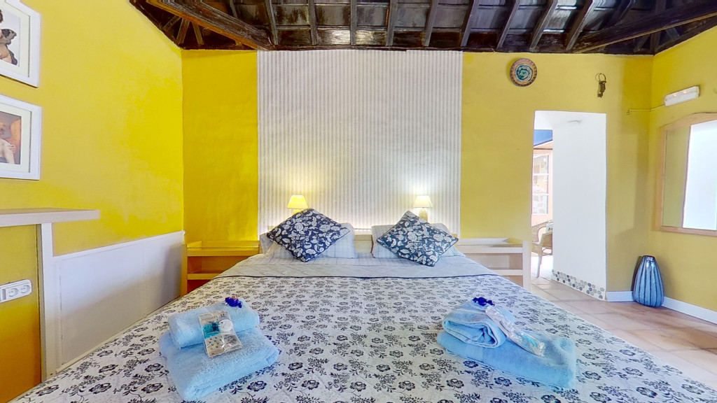 Schlafzimmer mit Doppelbett, gelben Wänden und Decke in einem Hotel in La Orotava, Teneriffa.