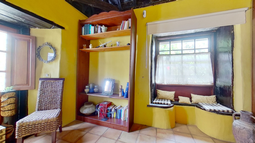 Gemütlicher Raum mit Bücherregal und Sitzbank in historischer Unterkunft in Tenerife.