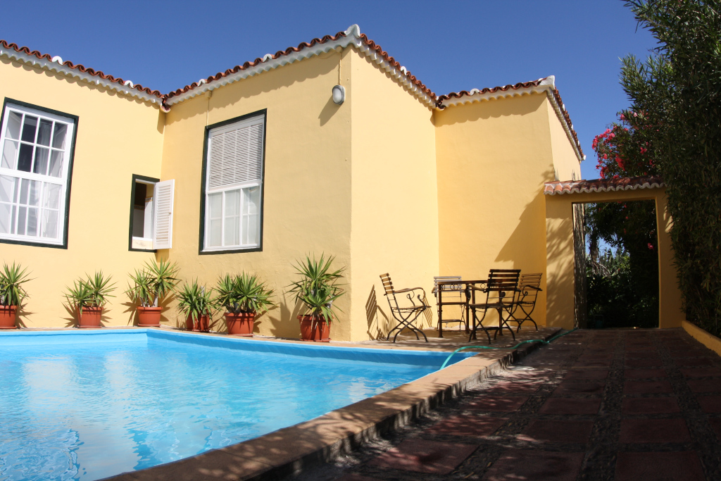 Gelbes Haus mit Pool und Gartenmöbeln in Puerto de la Cruz, Teneriffa.