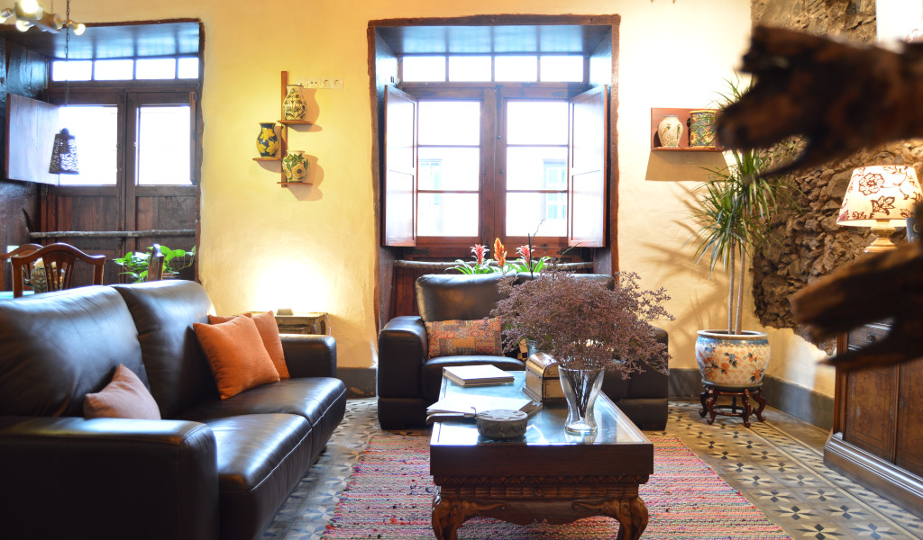Wohnzimmer mit Ledersofa, Pflanzen und Fenster in einem traditionellen Haus in La Orotava, Teneriffa.
