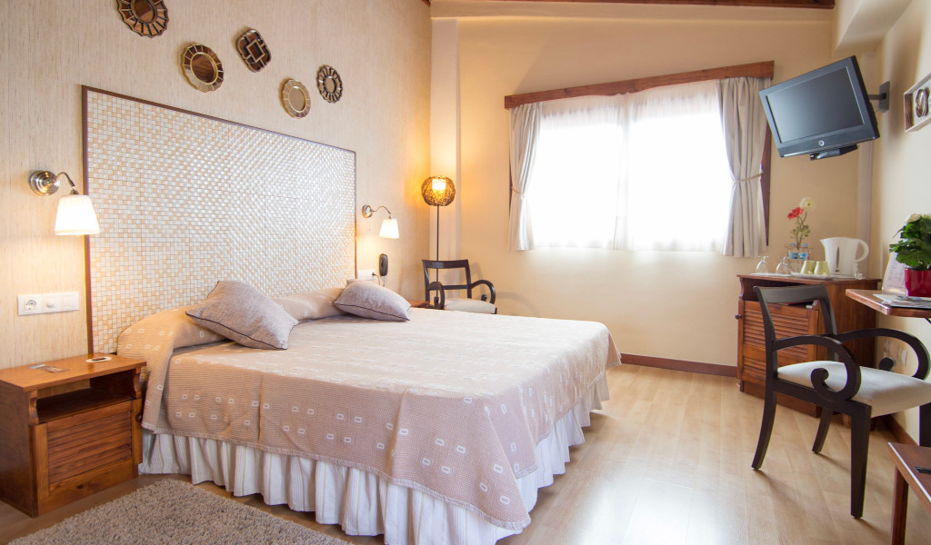 Gemütliches Hotelzimmer in San Cristóbal de La Laguna, Teneriffa, mit Doppelbett und TV.