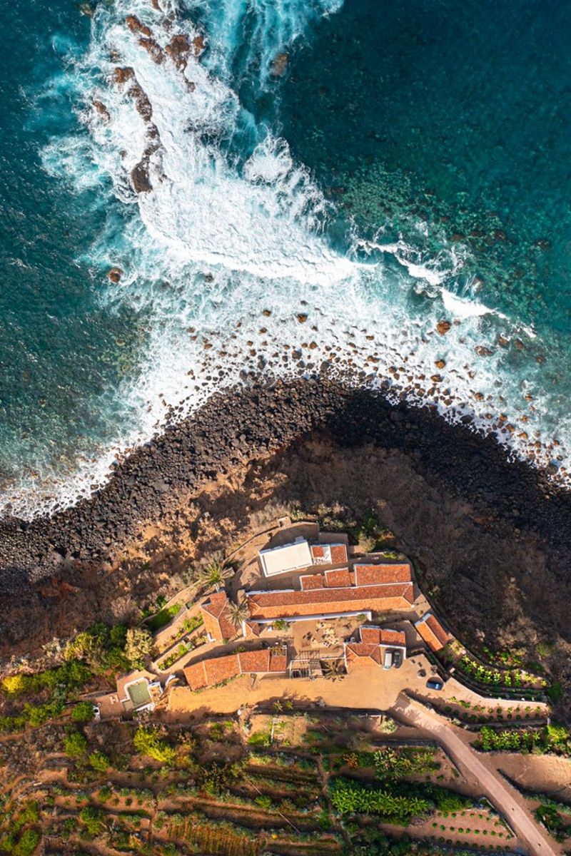 Küste mit Wellen und Landgut in Teneriffa aus der Vogelperspektive.