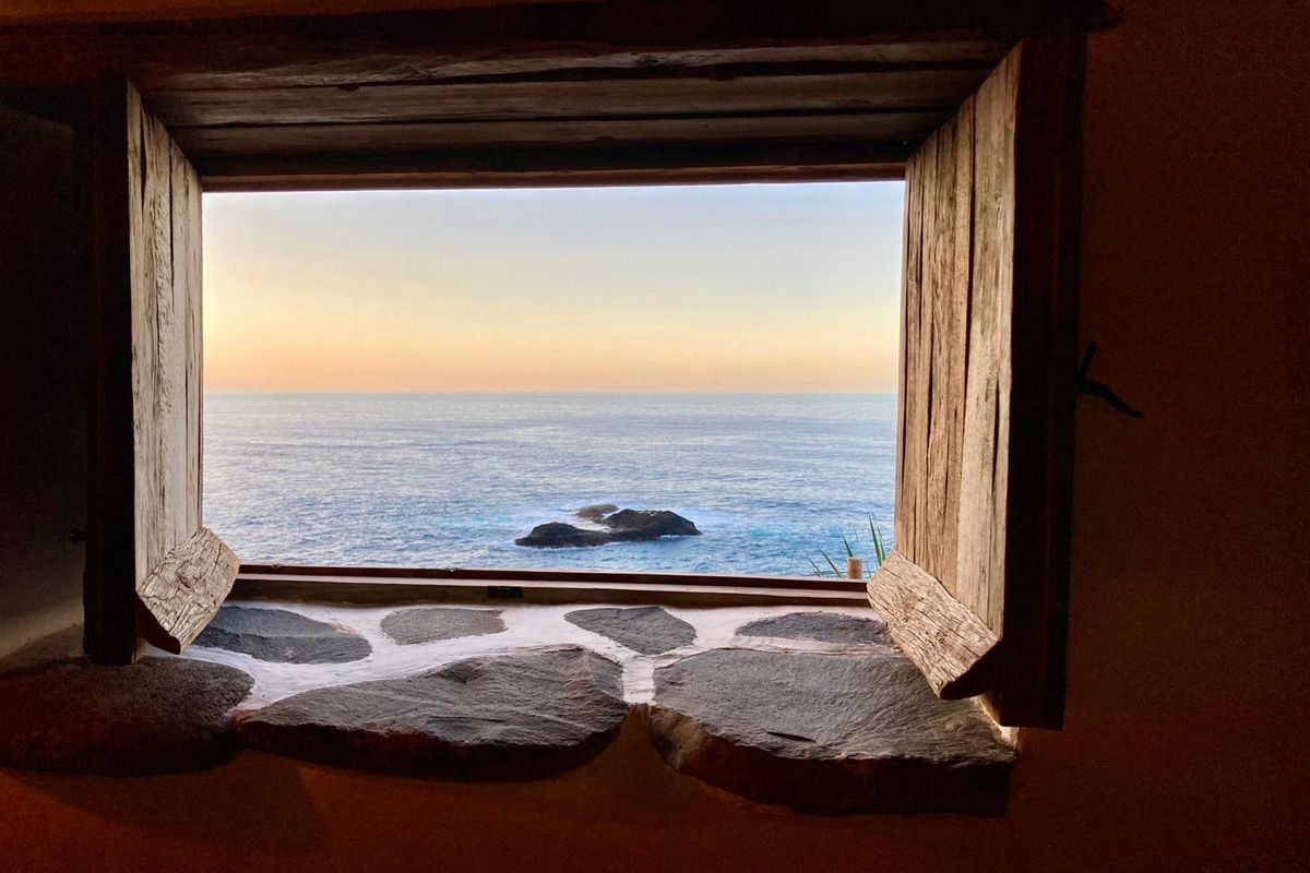 Offenes Fenster mit Blick auf das Meer bei Sonnenuntergang in Tenerife.
