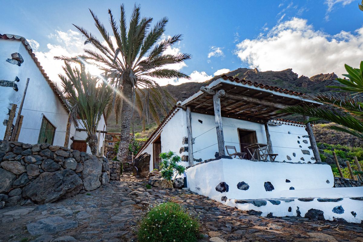Weißes Landhaus und Palmen in der ländlichen Landschaft von Tenerife.