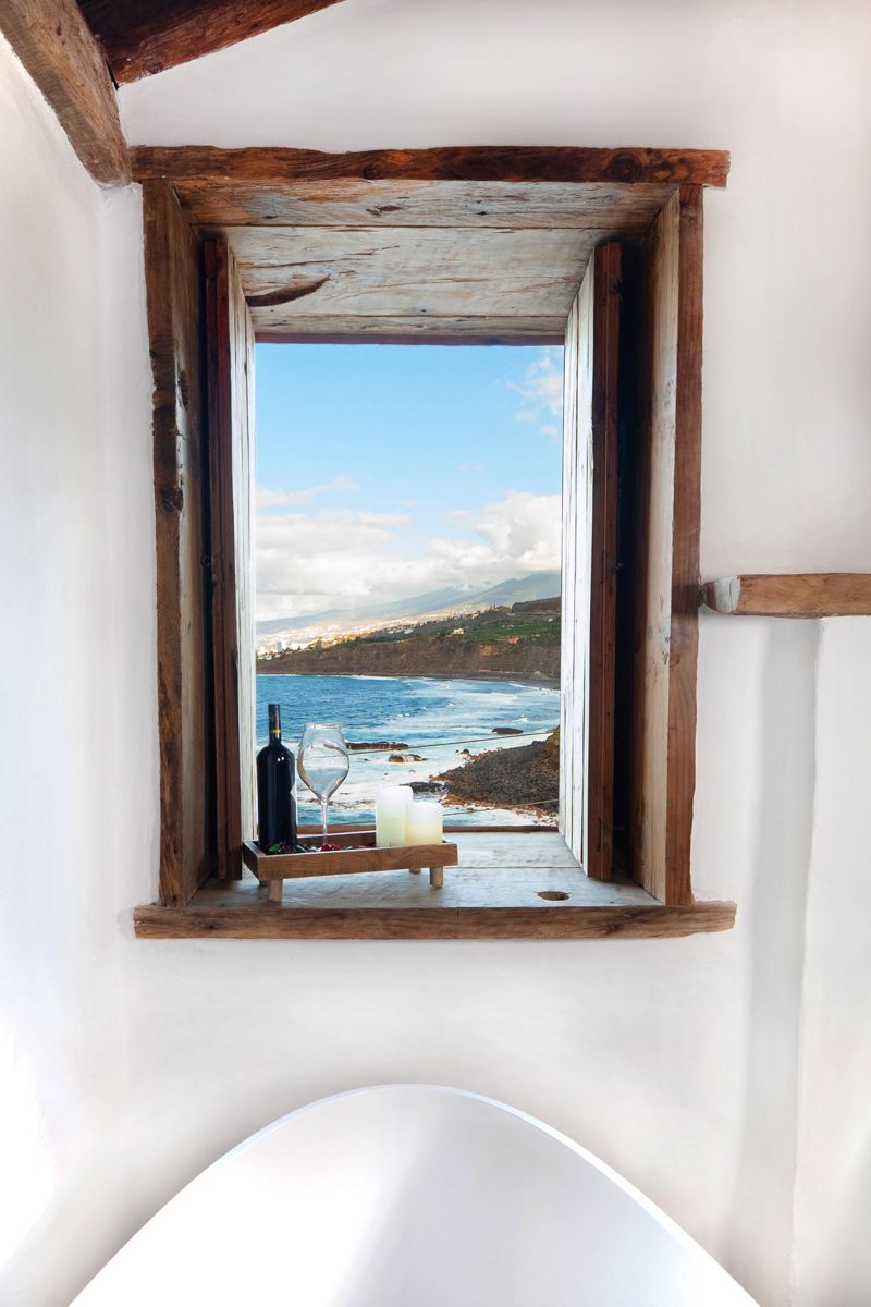 Weitblick auf den Ozean in Tenerife mit Weinflasche und Glas auf Fensterbank.