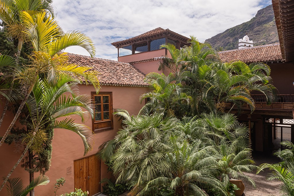Kolonialstilgebäude in La Orotava, umgeben von Palmen und Bergen im Hintergrund.