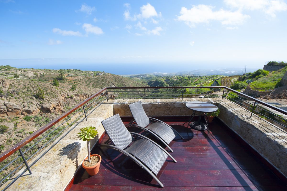 Zwei Liegestühle auf Terrasse mit Blick auf Landschaft und Meer in Tenerife.