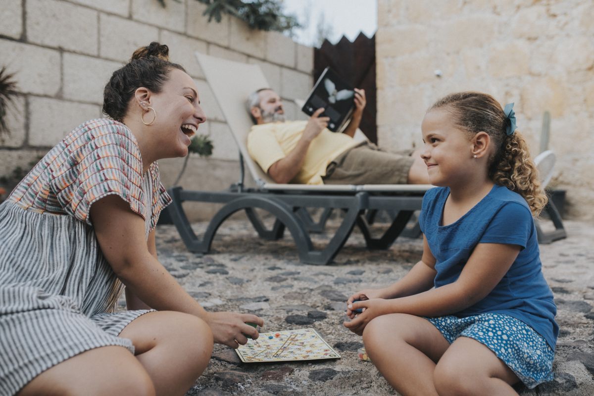 Frau und Mädchen spielen ein Brettspiel im Hof auf Teneriffa.