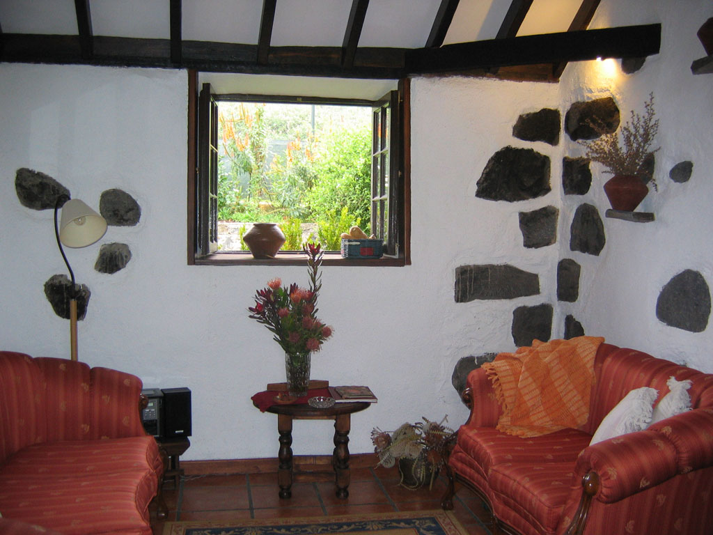 Wohnzimmer mit Fensterblick auf Garten in einem traditionellen Haus in Tenerife.