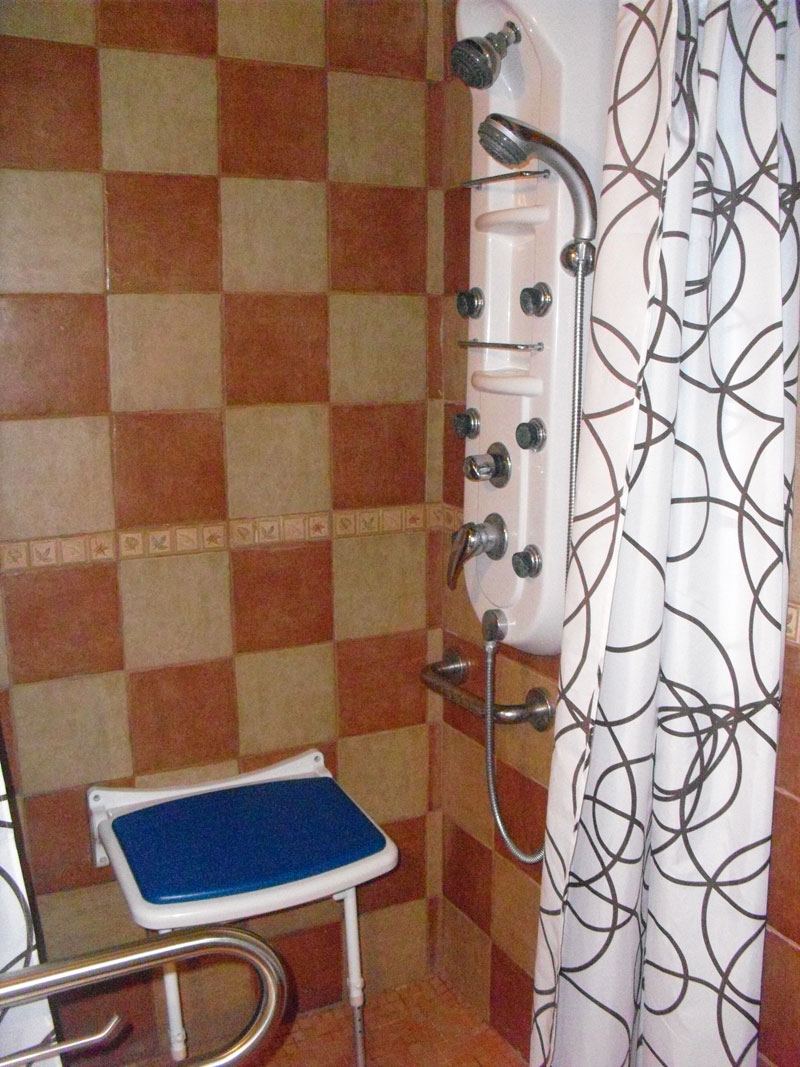 Barrierefreies Badezimmer mit Duschsitz und Vorhang in Puerto de la Cruz, Teneriffa.
