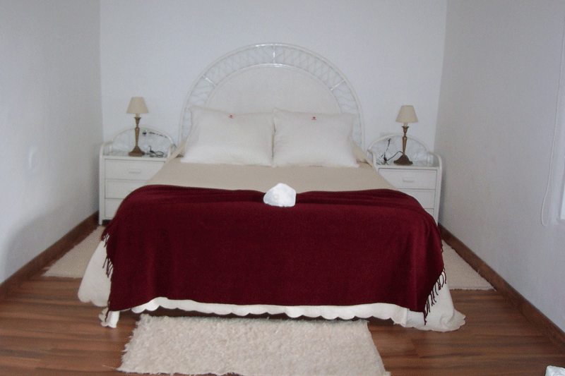 Bett mit roter Decke in einem Schlafzimmer in Puerto de la Cruz, Teneriffa.