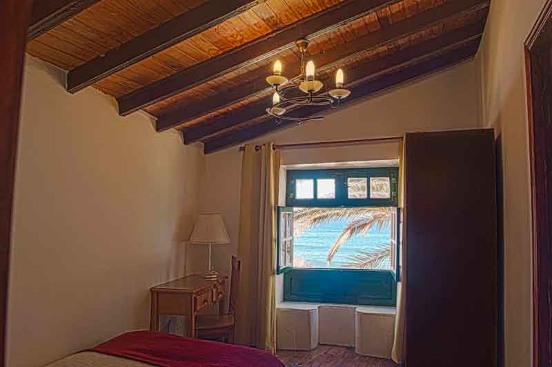 Kleines Zimmer mit Holzbalkendecke und Blick auf das Meer in Tenerife.