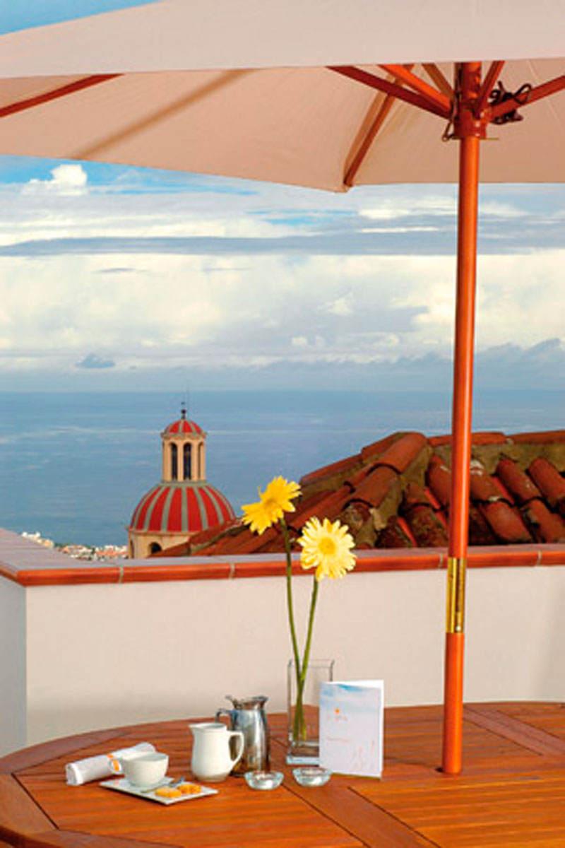 Terrasse mit Meerblick in La Orotava, Tisch mit gelben Blumen und Geschirr.