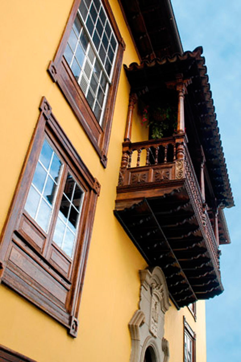 Holzbalkon und Fenster eines gelben Hauses in San Cristóbal de La Laguna, Teneriffa.