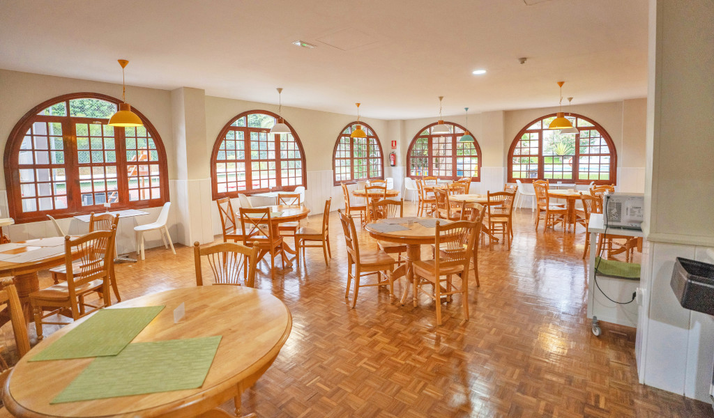 Speisesaal mit Holzböden und runden Holztischen in Puerto de la Cruz, Teneriffa.