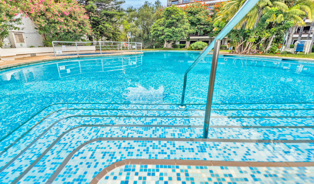 Schwimmbad mit Mosaikfliesen in Puerto de la Cruz, umgeben von Pflanzen.