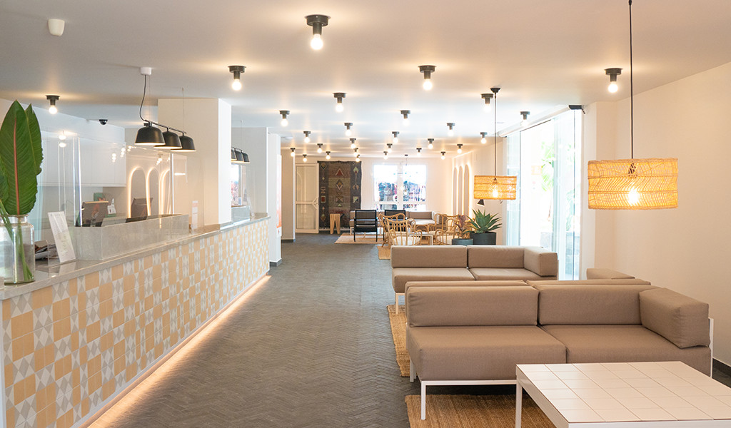 Hotelhalle in Teneriffa mit Sofas, Lampen und Rezeption.