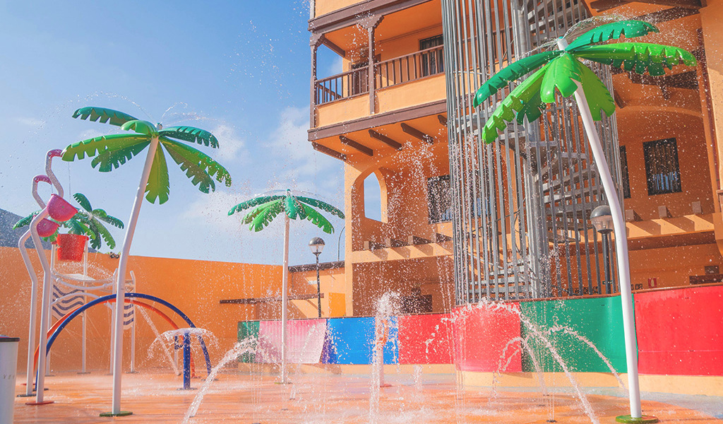 Wasserspielplatz mit Palmen und Rutschen im Hotel auf Teneriffa.