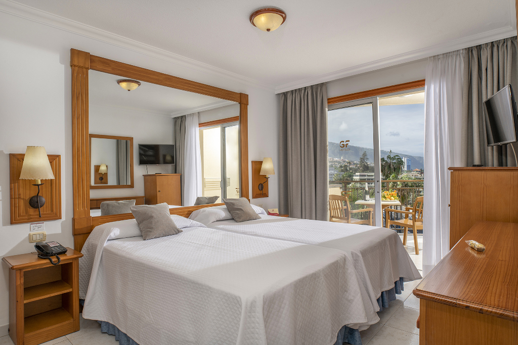 Zweibettzimmer mit Blick auf den Balkon und Puerto de la Cruz in Teneriffa.